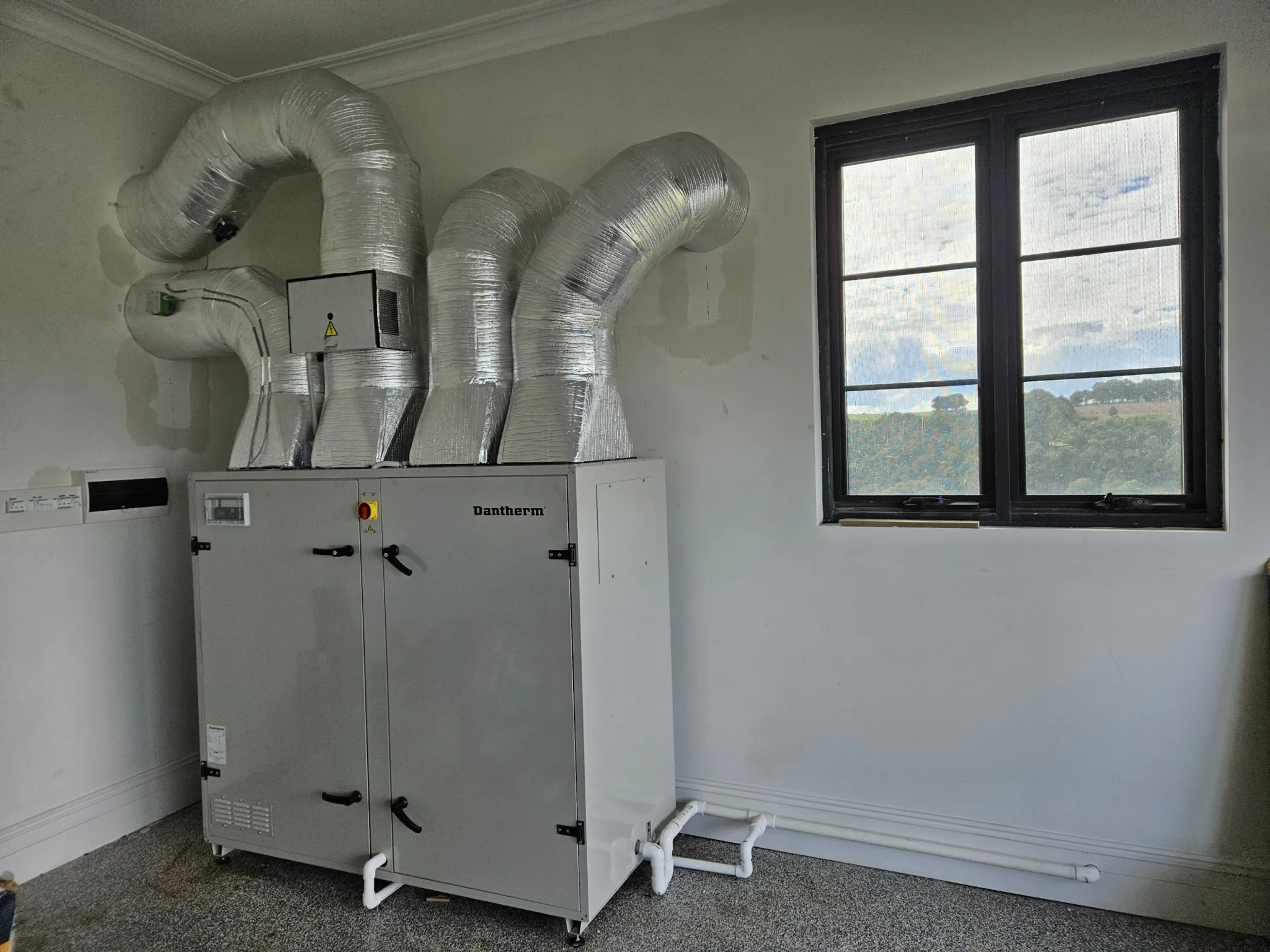 Heat recovery ventilation unit with insulated flexible ducts installed in a plant room