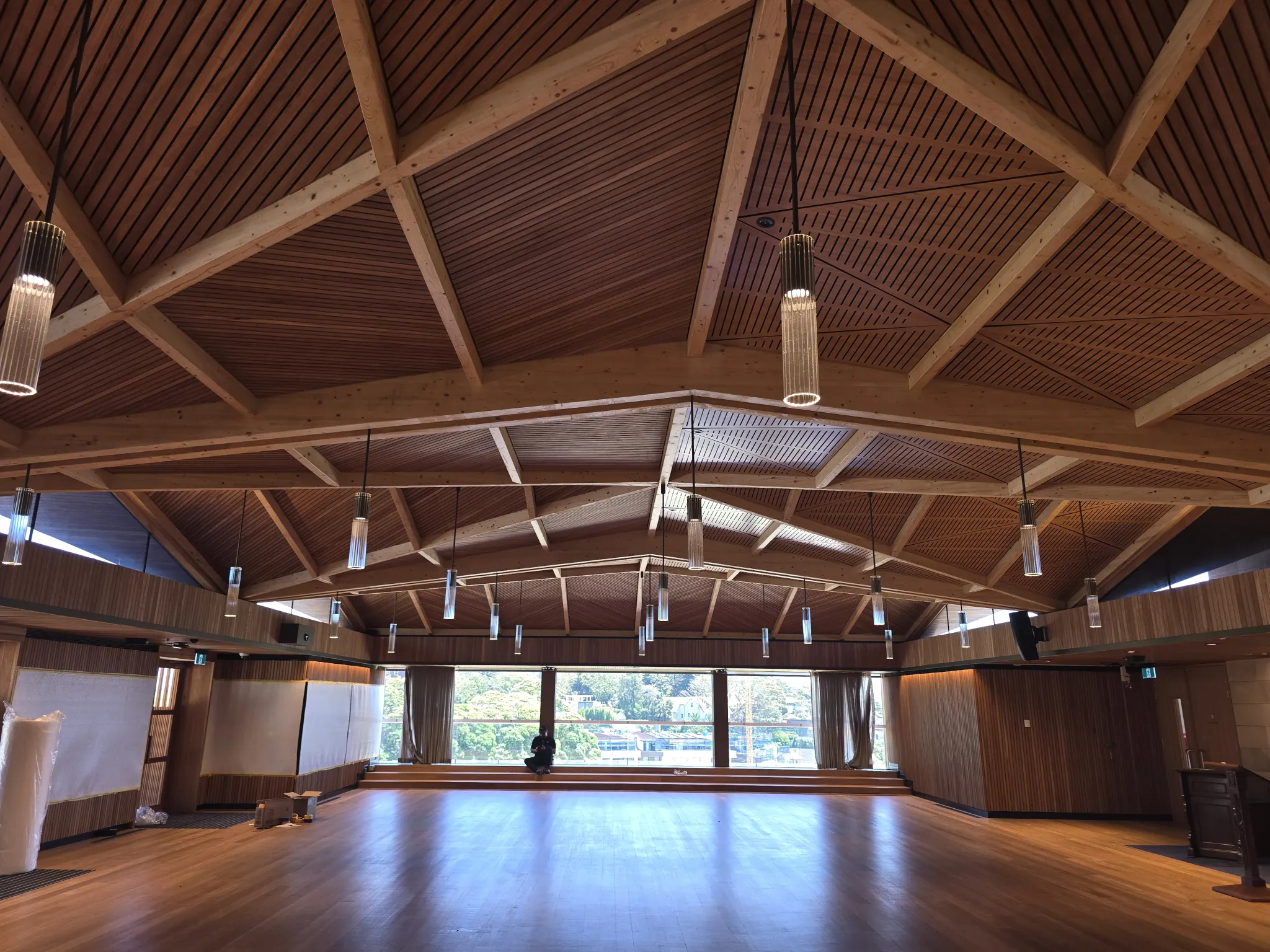 Timber-lined hall with exposed roof trusses and pendant lights
