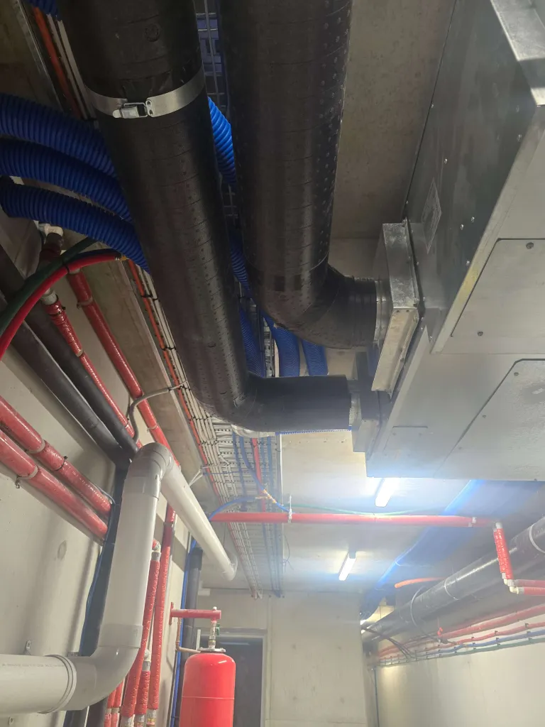 Plant room ceiling with insulated ductwork and blue supply pipes