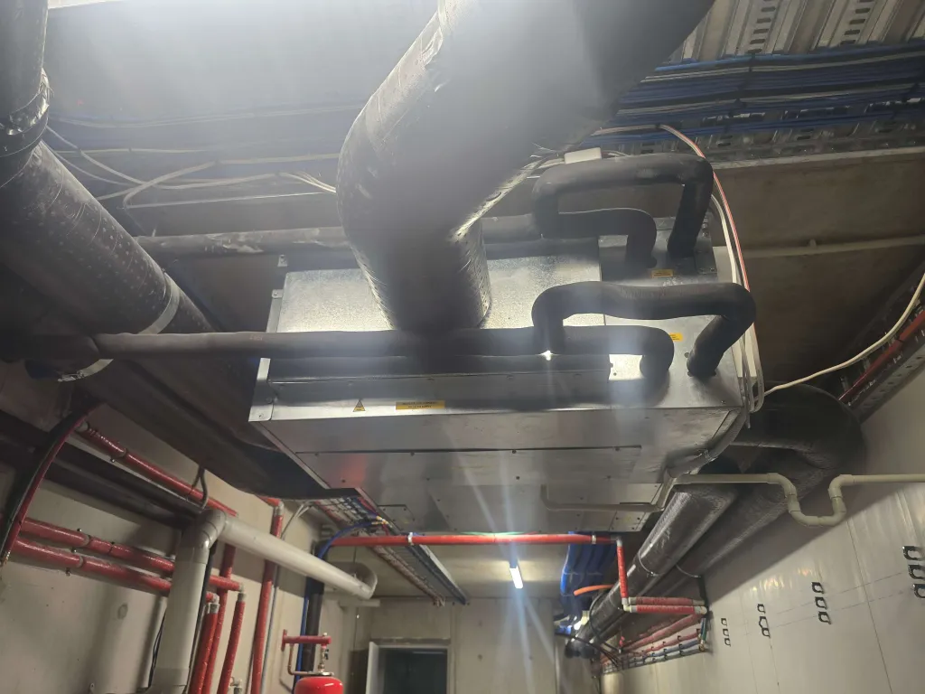 Underside of a ceiling-mounted HiDEW RER100 unit with insulated duct connections