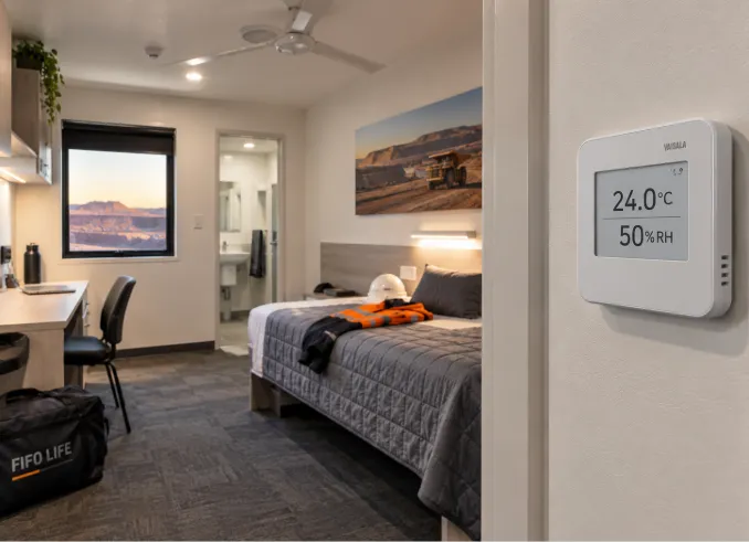 Mining accommodation room with a wall controller showing 24 °C and 50% relative humidity