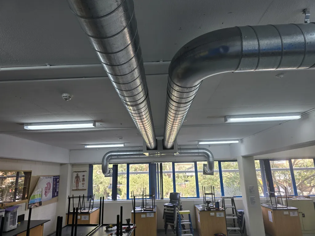 Spiral supply ductwork installed across a school science lab ceiling