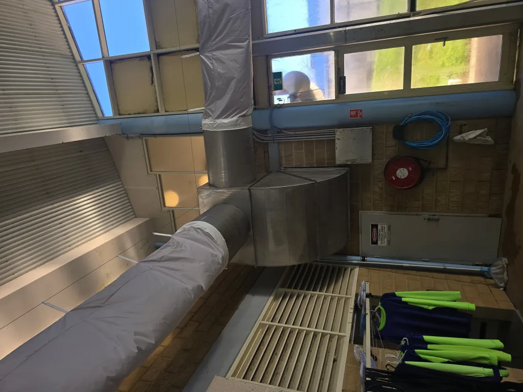 Insulated supply duct and grille installed in the school pool hall